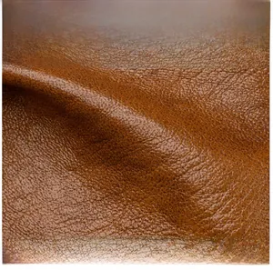 Close-up of brown litchi grain leather texture showing soft and skin-friendly fabric