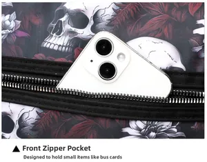 Detailed view of front zipper pocket on skull print shoulder bag holding a smartphone