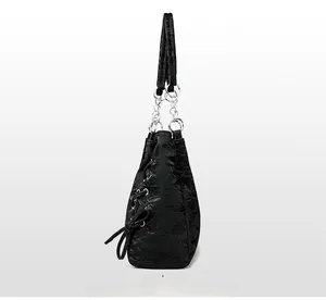 Detail of black pleated tote bag with side lacing and silver metal chain strap