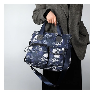 Detail of dark blue tote bag with white skull and purple floral print on nylon fabric