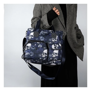 Detail of floral skull print tote bag with front pockets and nylon shoulder strap