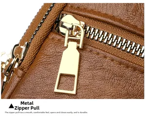 Detail of brown litchi pattern leather with polished gold metal zipper puller