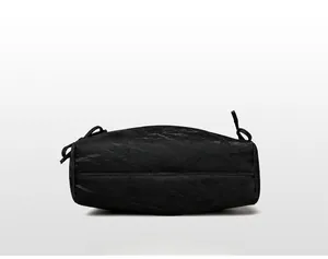 Detail view of the black tote bag bottom with pleated texture and reinforced stitching