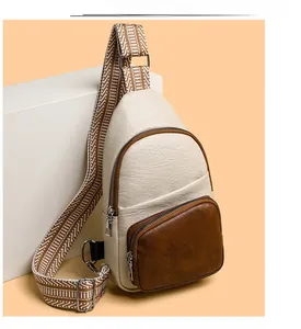 Detail of crossbody chest bag featuring lychee grain faux leather and striped strap