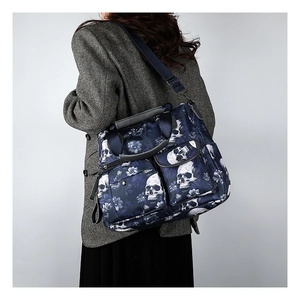 Detail of navy skull and floral tote bag with multiple pockets and adjustable strap