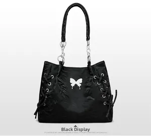 Detail of black tote bag with white butterfly print and silver chain leather strap