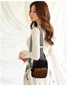 Detail view of stylish crossbody bag with black and brown contrast and geometric strap