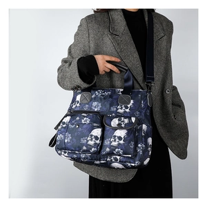 Detail of skull print tote bag featuring zip front pockets and durable canvas texture