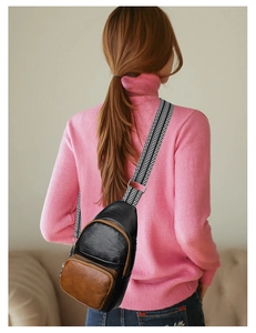 Detailed back view of a faux leather chest bag with woven geometric strap on model
