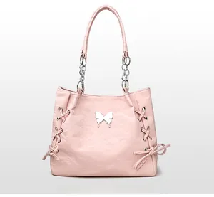Detail of pink tote bag with silver bow hardware and leather chain strap design