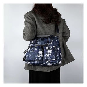 Detail of skull print tote bag with multiple zip pockets and adjustable strap