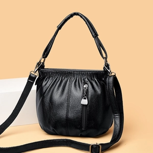 Black PU leather bucket bag with soft texture and adjustable strap on a white stand