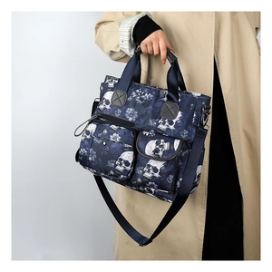 Detail of the blue gothic skull and floral print tote bag with multiple pockets