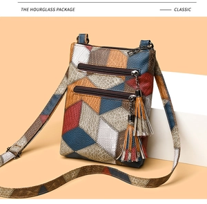 Close-up of vintage multi-color patchwork PU leather bag with dual tassels and snake pattern