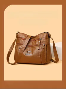 Detailed macro of the brown leather texture and functional zippers on the shoulder bag