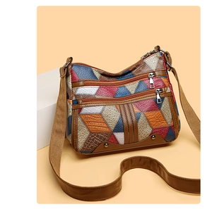 Detail of colorful patchwork leather handbag with multi-zipper layers and lychee texture