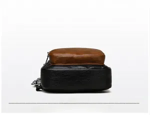 Detailed bottom view of a two-tone cross-body bag with textured pebble leather and stitching