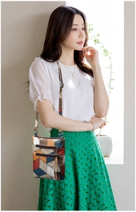 Vertical multi-pocket crossbody bag with colorful patchwork and tassel detail shown on model