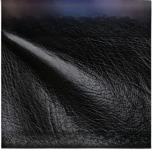 Detailed macro view of high-quality black lychee texture leather with soft finish