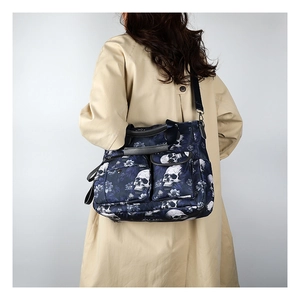 Detail of skull floral tote bag on model showing large capacity and crossbody strap