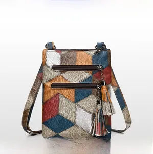 Detail of vintage patchwork leather handbag with zippers, tassel charms, and lychee texture