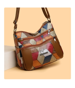 Dettaglio di borsa in pelle multicolore con scomparti multipli e cerniere in metallo lucido
