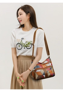 Detail view of colorful patchwork crossbody bag with multi-zipper pockets and adjustable strap