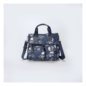 Detail of dark blue skull and floral print tote bag with multiple pockets and zippers