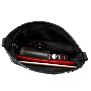 Spacious tote interior with skull print holding a tablet, wallet, and accessories