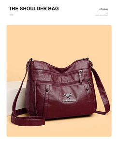 Detail shot of burgundy pebbled leather texture with a silver kangaroo metal logo