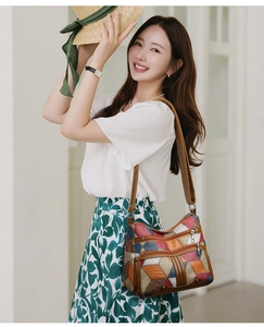 Detail of multi-color patchwork leather crossbody bag with multiple zippered pockets