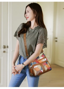 Detailed close-up of a multi-color patchwork leather crossbody bag on a model