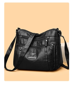 Detail of lychee pattern PU leather and multiple zip compartments on black crossbody bag