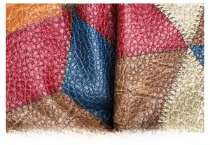 Macro detail of multicolored patchwork leather with pebbled texture and zigzag stitching