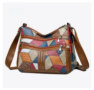 Macro side view of geometric patchwork shoulder bag with textured leather and front zippers