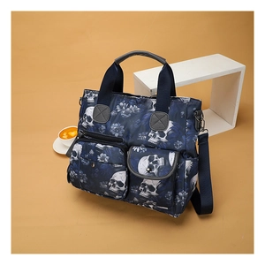 Detail of blue skull print tote bag with multiple pockets and adjustable shoulder strap