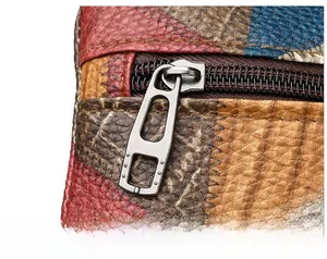 Macro detail of high-quality metal zipper and colorful patchwork lychee grain leather