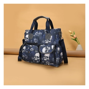 Detail view of navy skull floral tote bag with functional pockets and sturdy handles