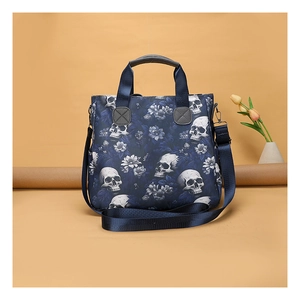 Detail of skull floral tote bag showing durable handles and adjustable blue shoulder strap