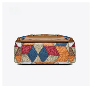 Macro detail of the color-block patchwork leather bag bottom with protective metal studs
