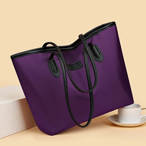 Minimalist purple large capacity tote bag with black leather straps on a warm backdrop