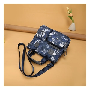 Detail showing skull print tote bag with multiple zip pockets and adjustable strap
