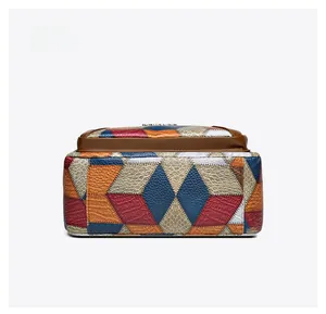 Dettaglio del patchwork geometrico colorato e della trama a coccodrillo sul fondo della borsa