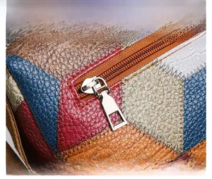 Dettaglio in pelle patchwork colorata con trama a grana e cursore della zip in metallo