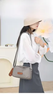 Detailed view of grey waterproof oxford crossbody bag with adjustable branded strap