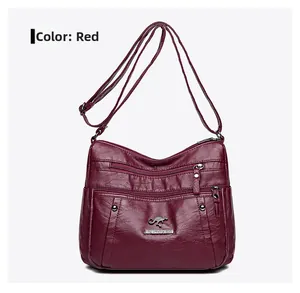 Close-up of wine red PU leather shoulder bag featuring multi-zipper pockets and metal logo