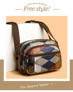Detail of color-block crossbody bag featuring geometric patterns and multi-zip compartments