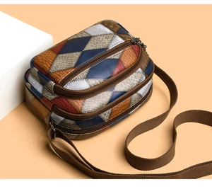 Detail view of multi-compartment retro color-block bag with litchi and croc textures