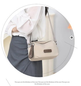 Detailed close-up of beige waterproof nylon shoulder bag with adjustable fabric strap