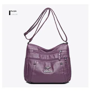 Close-up of purple faux leather bag showing lychee grain texture and metal zipper pockets
